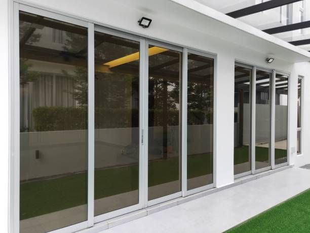 A white building with a lot of windows and sliding glass doors
