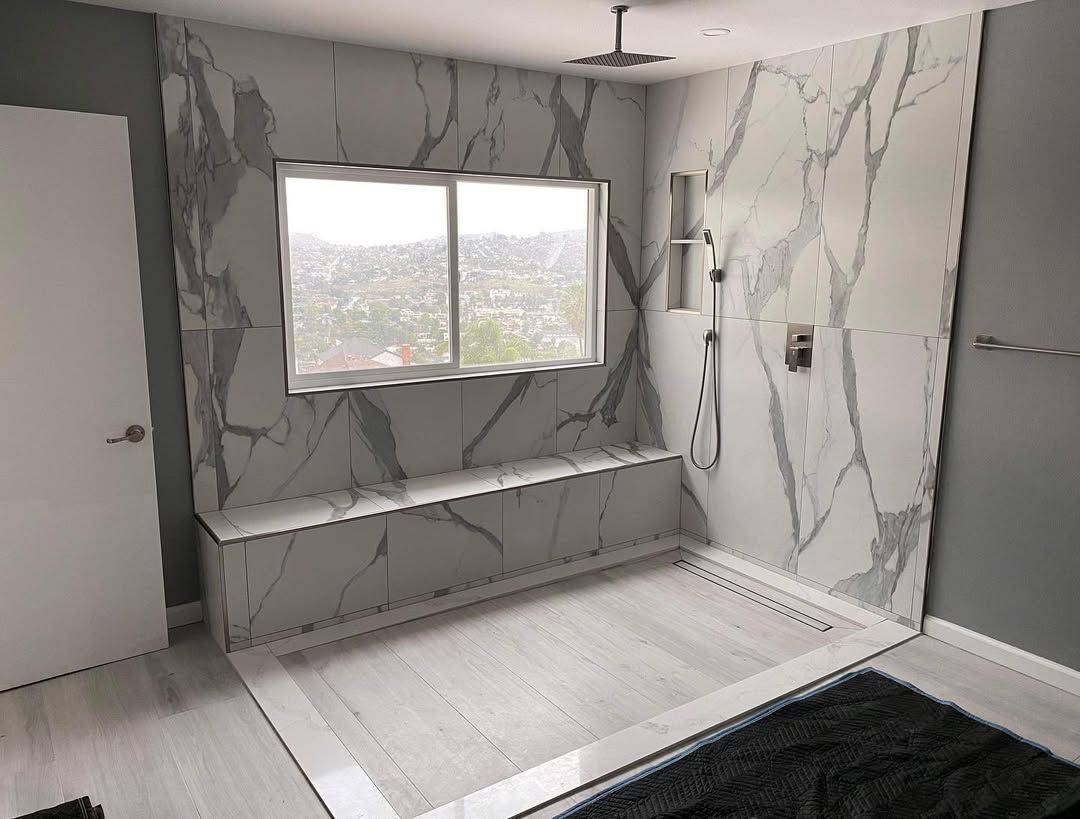 A bathroom with marble walls and a large window.