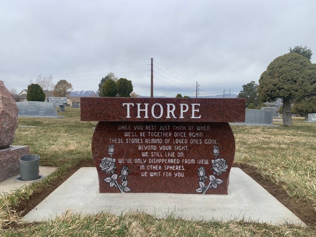 Red granite Thorpe family headstone in a cemetery.