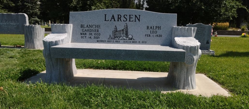 A gravestone shaped like a bench, marked LARSEN in a cemetery.
