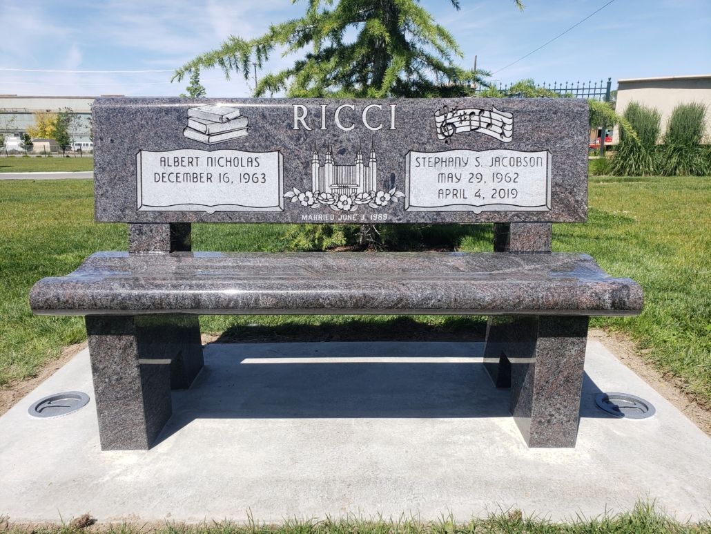 Granite bench memorial, outdoors, inscribed Ricci, with names and dates of birth and death.