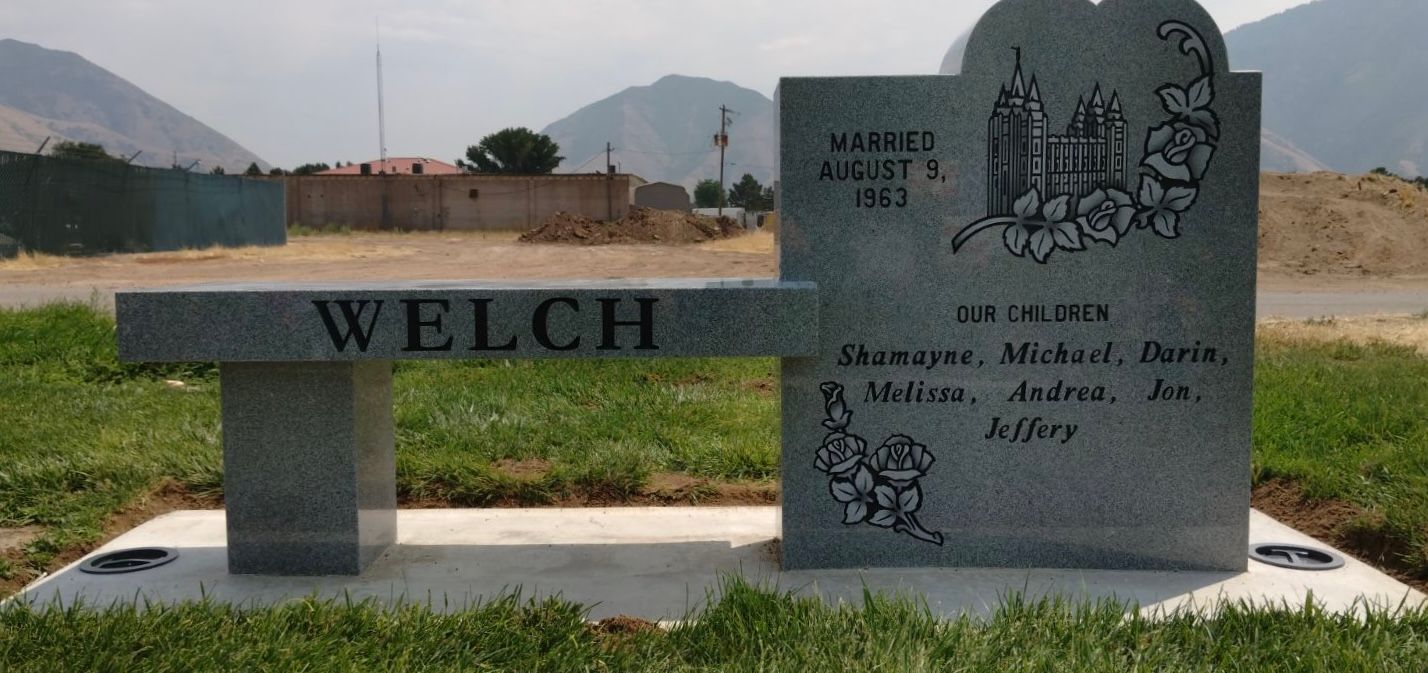 A gravestone and bench in a cemetery. Welch is inscribed on the bench. 