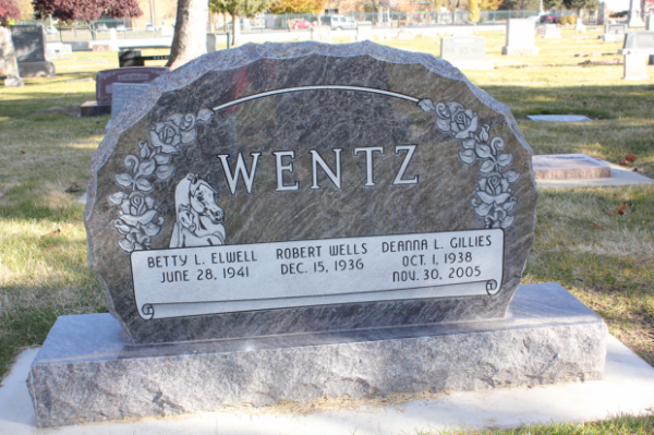 Stone gravestone with floral carving and the name WENTZ in a cemetery