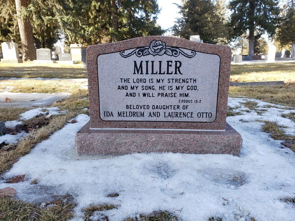 Headstone in a snowy cemetery,