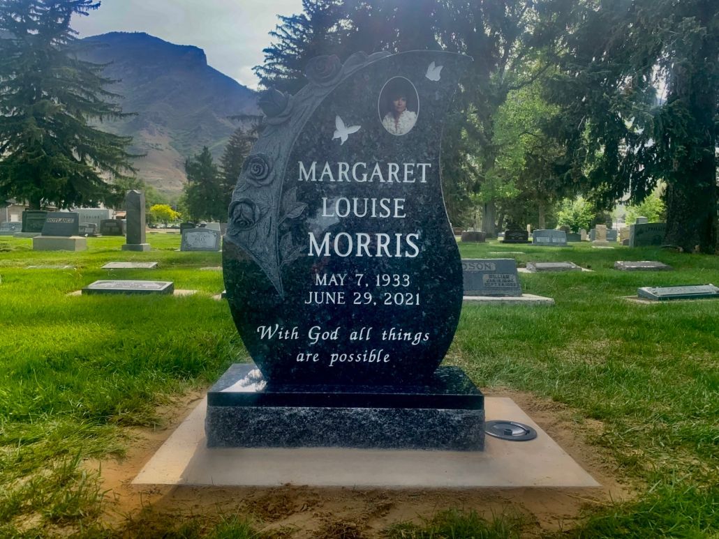 Black granite headstone for Margaret Louise Morris in a cemetery.  It has a photo, birth & death dates, and a quote.