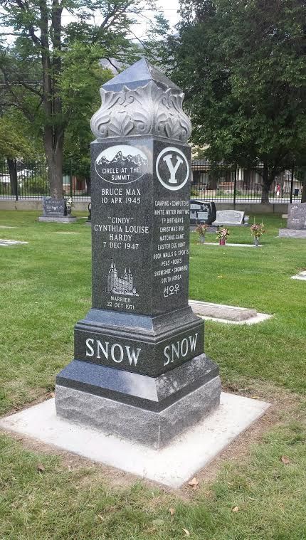 Tall, ornate, black granite Snow family tombstone in a cemetery.