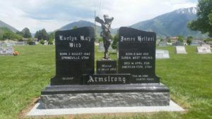 Gravestone with names Evelyn and James Armstrong; a crucifix statue sits on top.