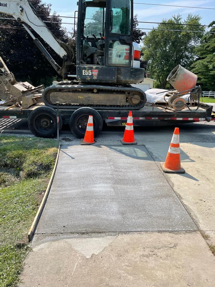 A bulldozer is parked on a trailer next to a sidewalk.