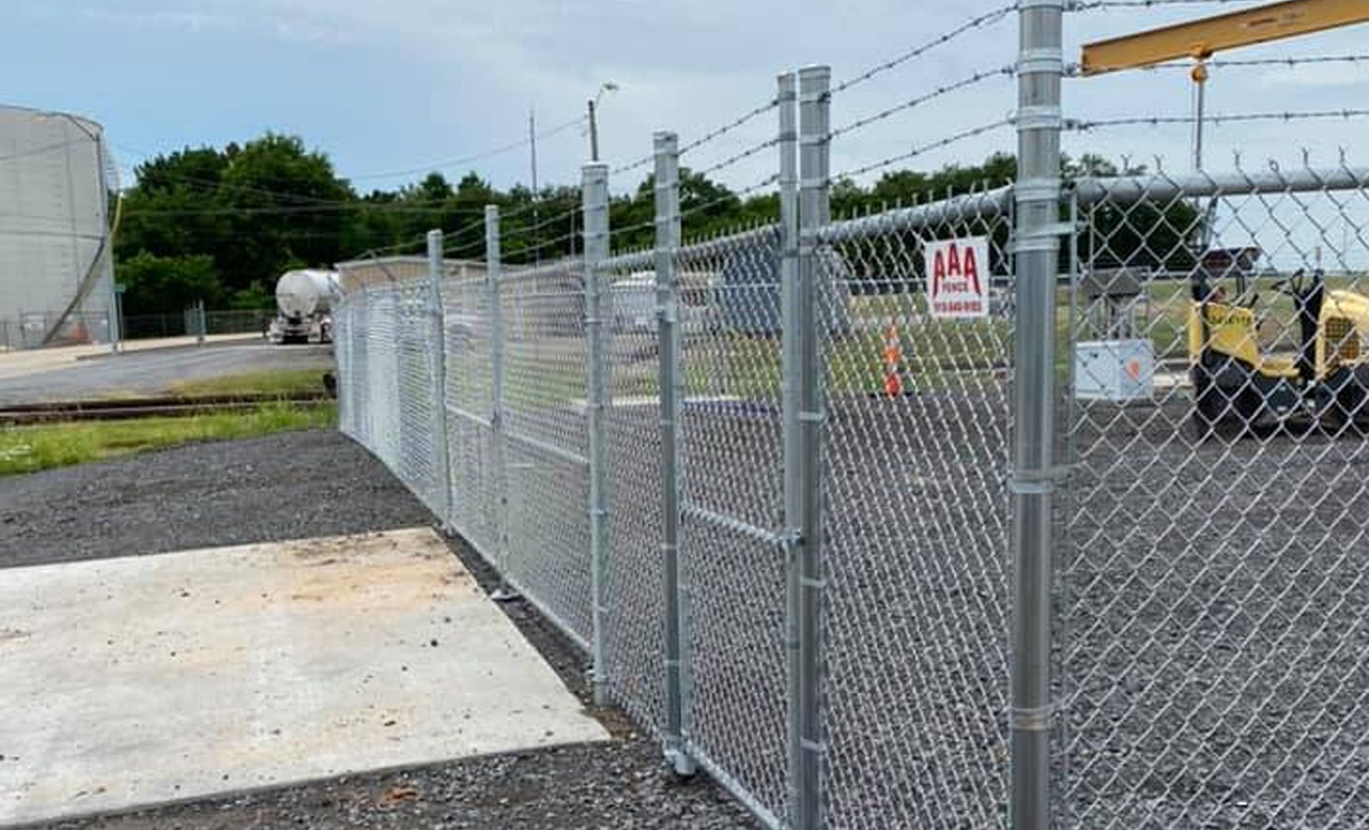 A chain link fence with barbed wire surrounding a construction site.