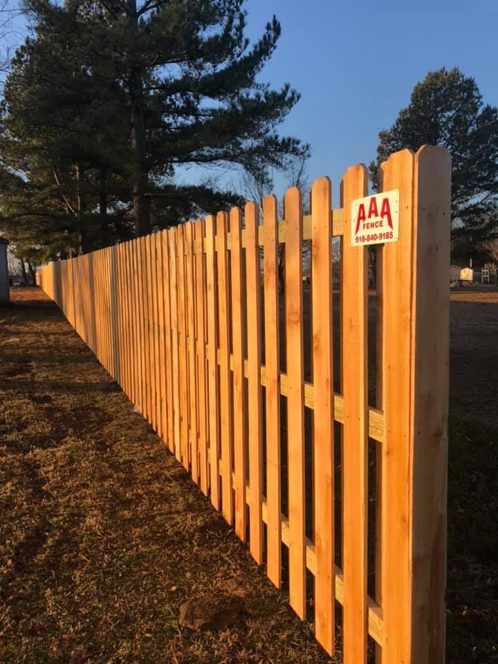 A wooden fence with a sign that says AAA on it