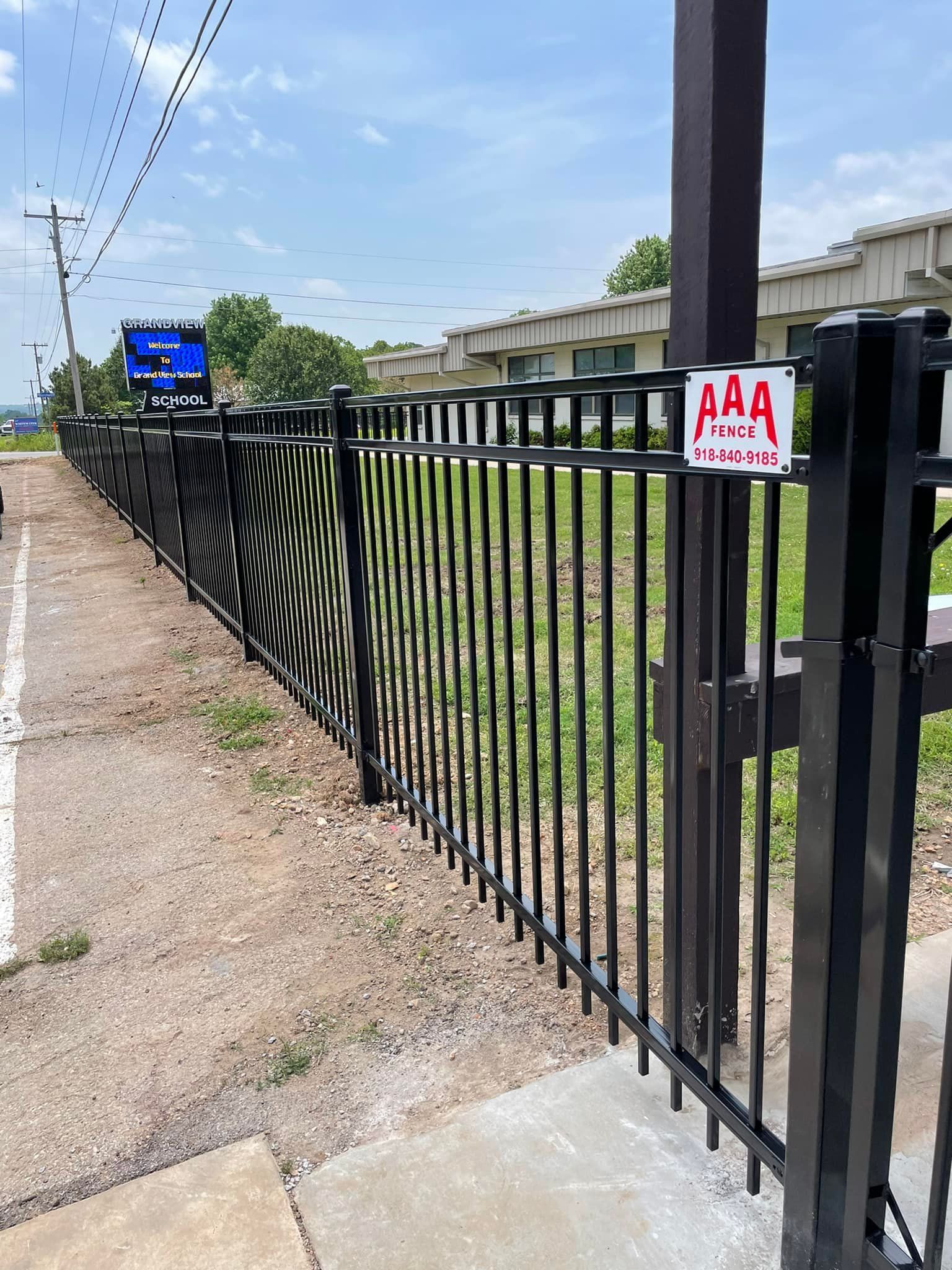 A black metal fence with a sign that says AAA on it.