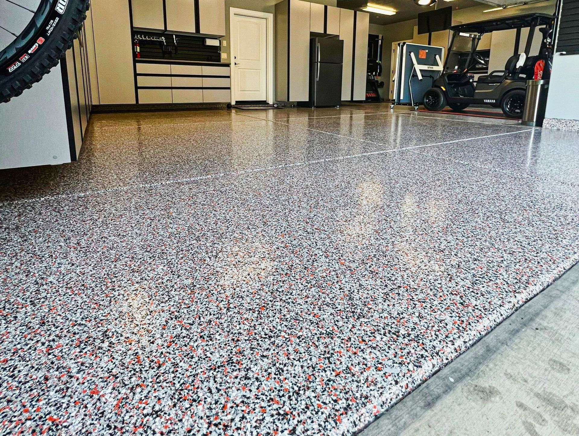 A garage with a motorcycle and a golf cart parked in it