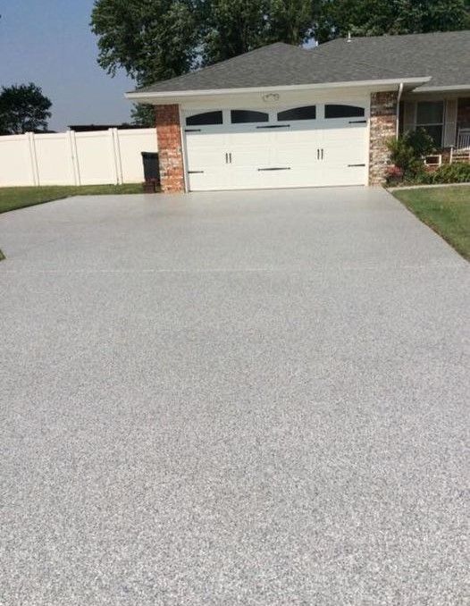 A driveway leading to a house with a garage door
