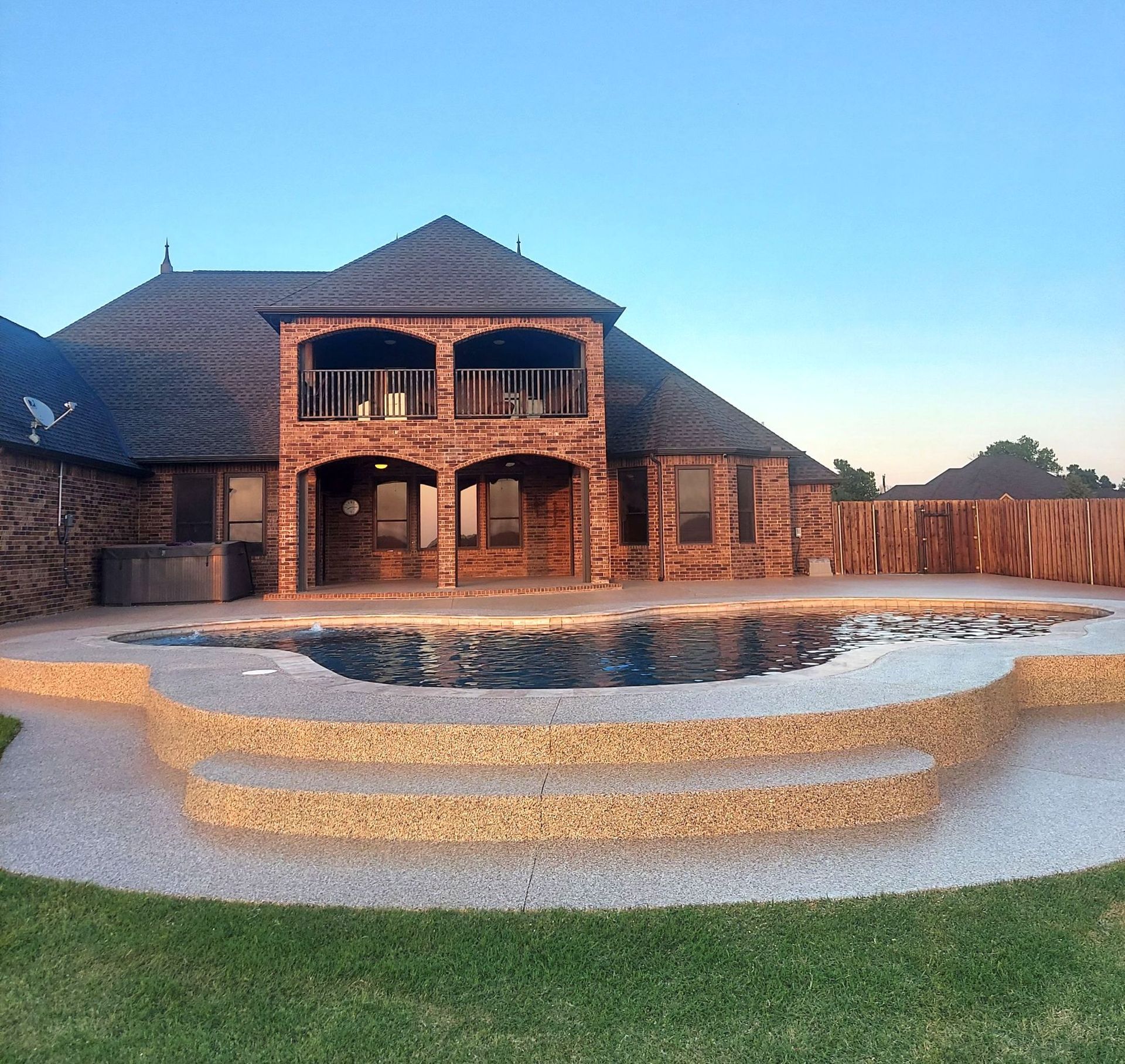 A large brick house with a swimming pool in front of it