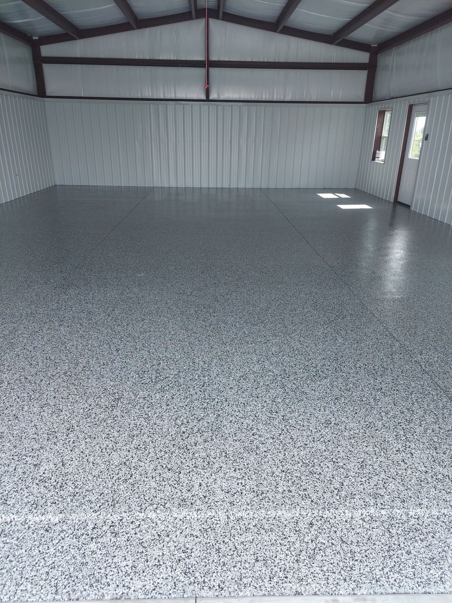 A large empty garage with a gray concrete floor