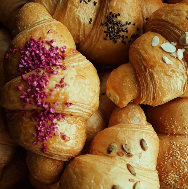 A pile of croissants with purple sprinkles on top.