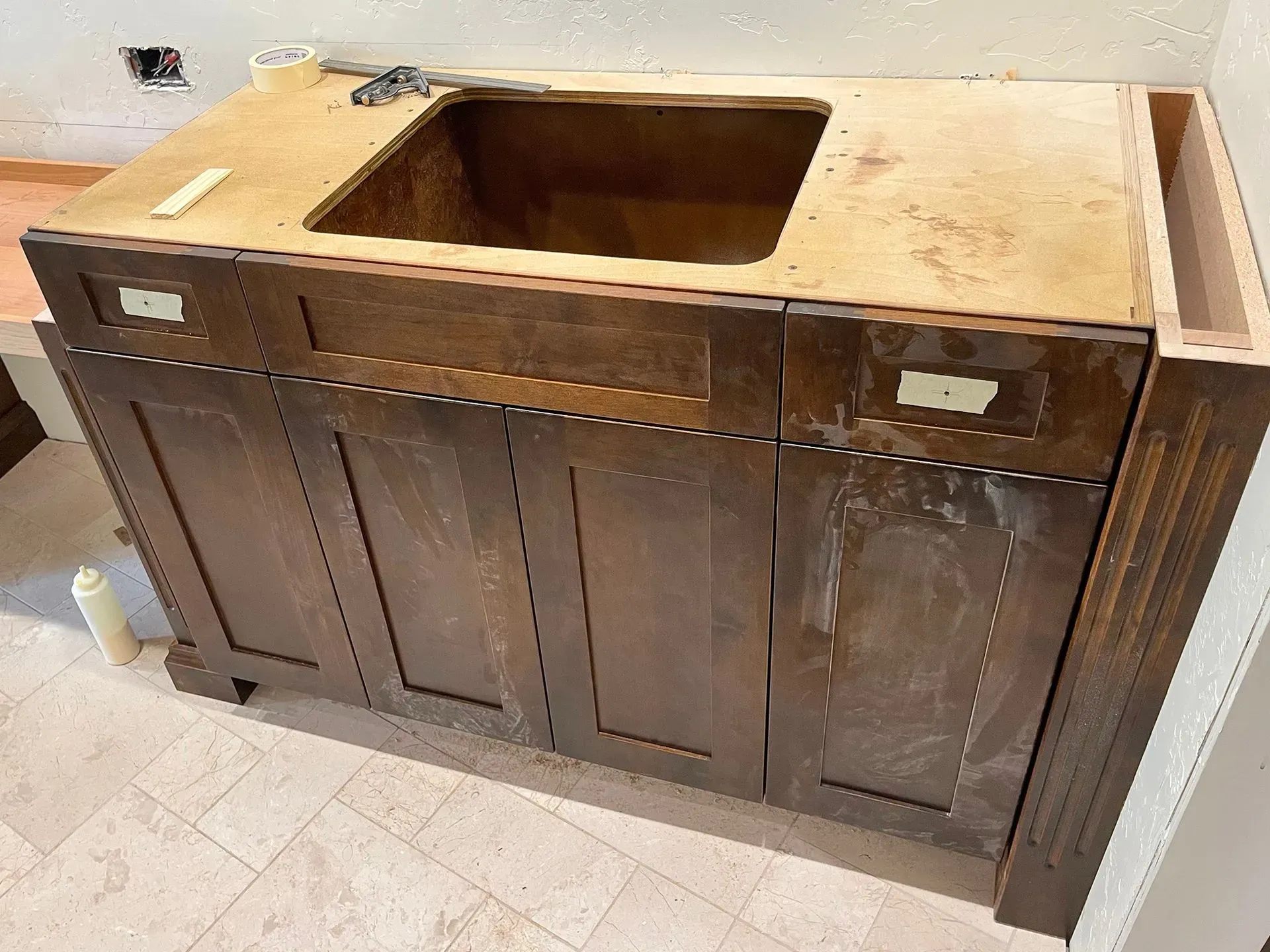 Dark wood bathroom vanity cabinet with a rectangular sink cutout and no countertop installed.