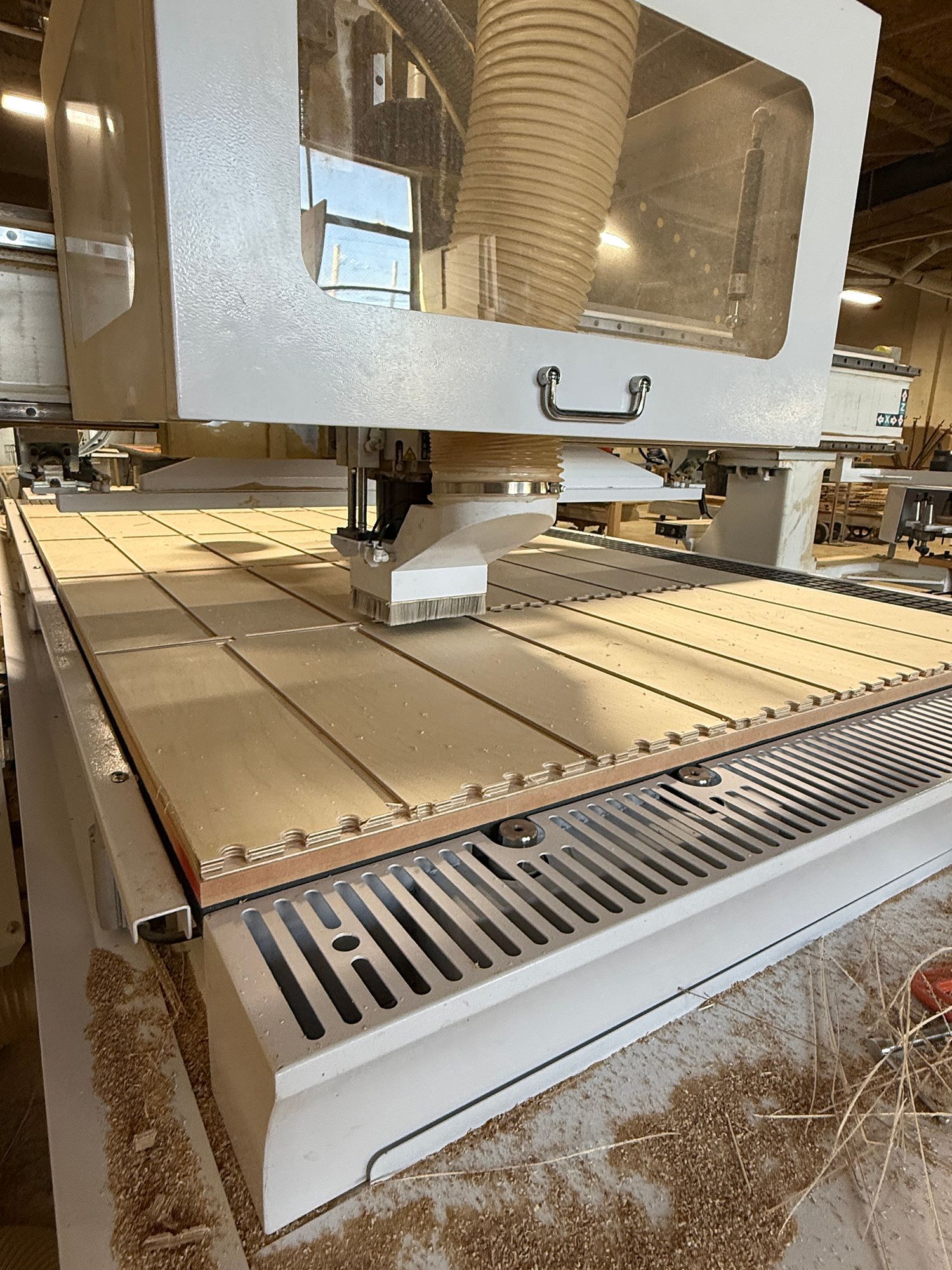 Industrial CNC machine with a spindle over a slotted worktable in a workshop