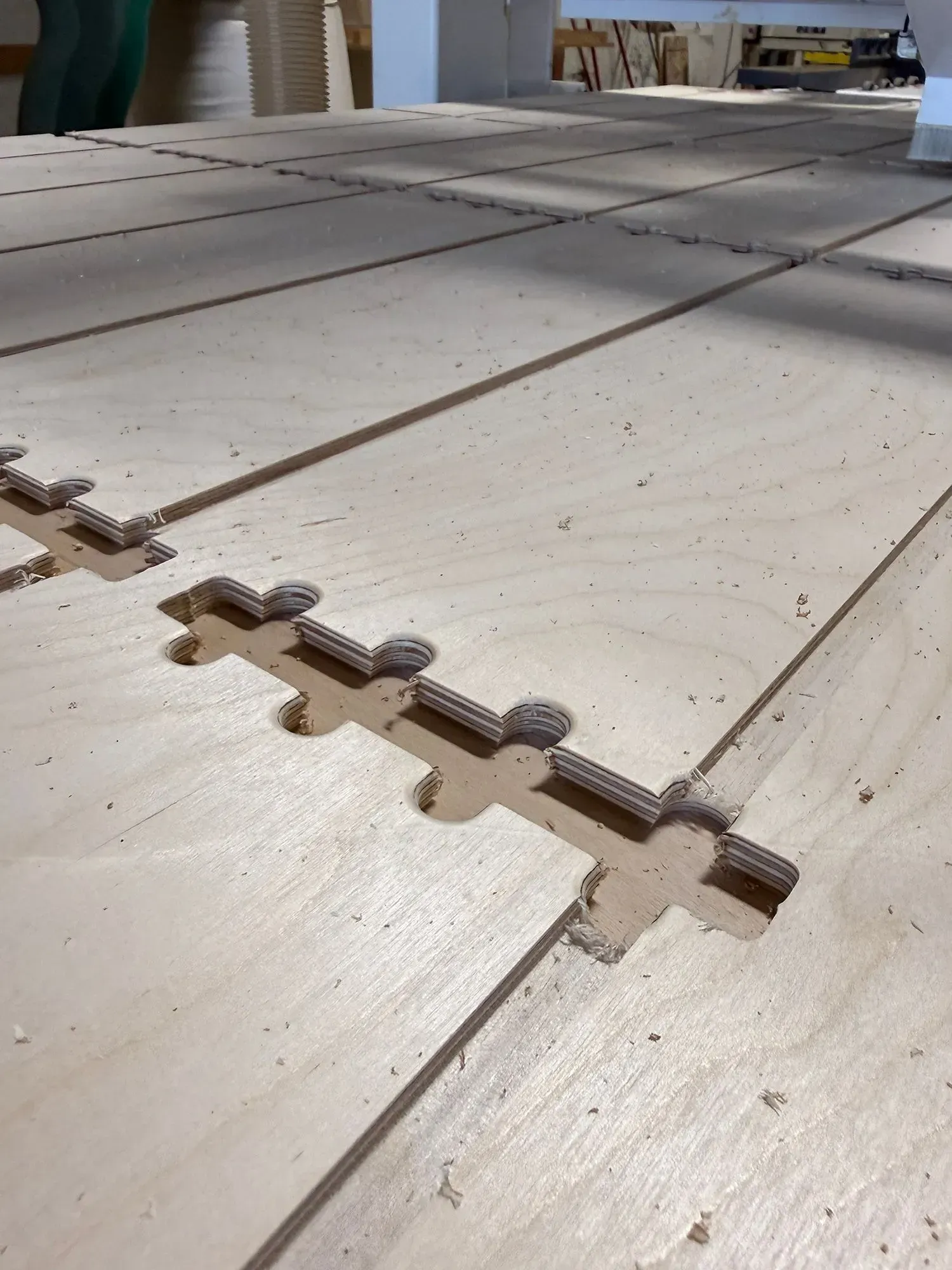 Interlocking wooden deck tiles laid out on a sunlit floor during installation.