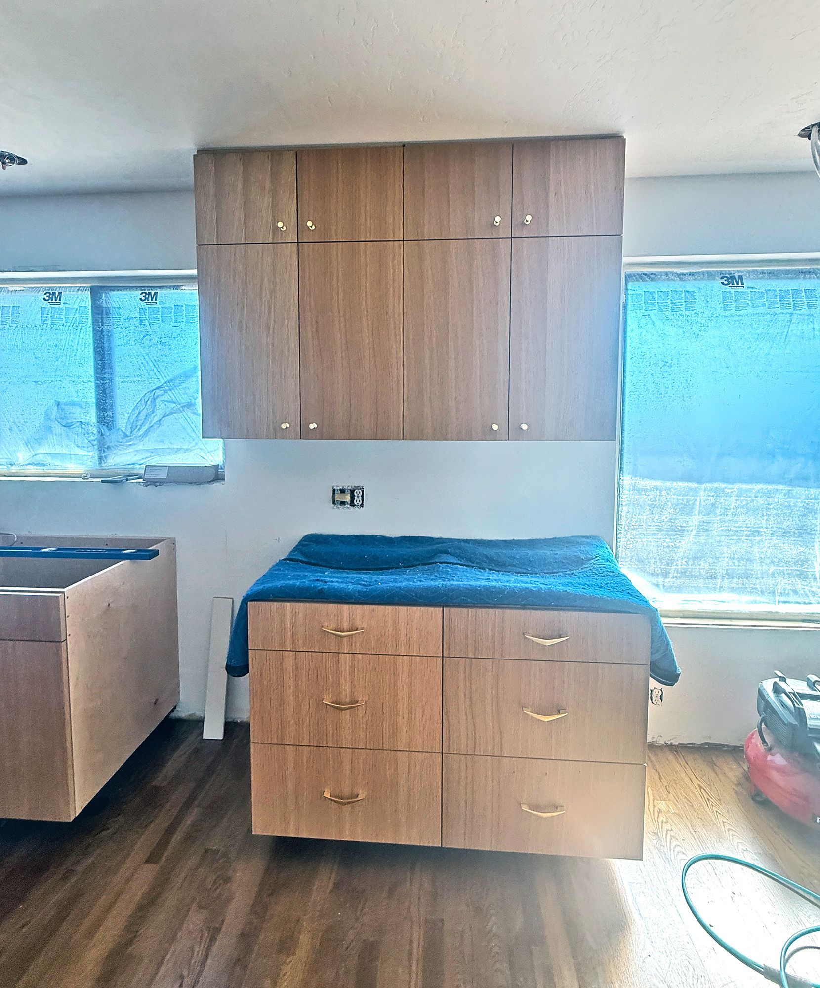 Wood-paneled cabinets and a blue-covered exam table in a bright medical room