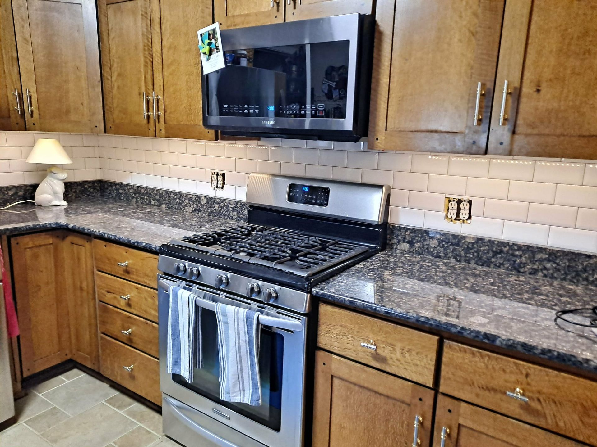 Kitchen with wooden cabinets, granite countertops, and stainless steel appliances.