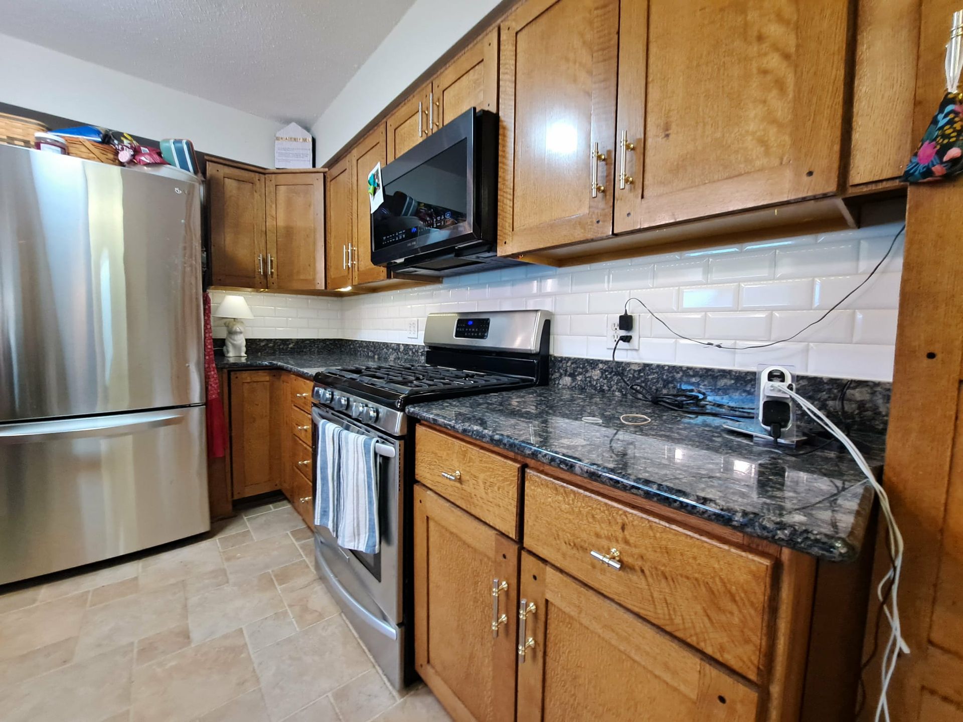 Kitchen with stainless steel appliances, wood cabinets, and granite countertops.