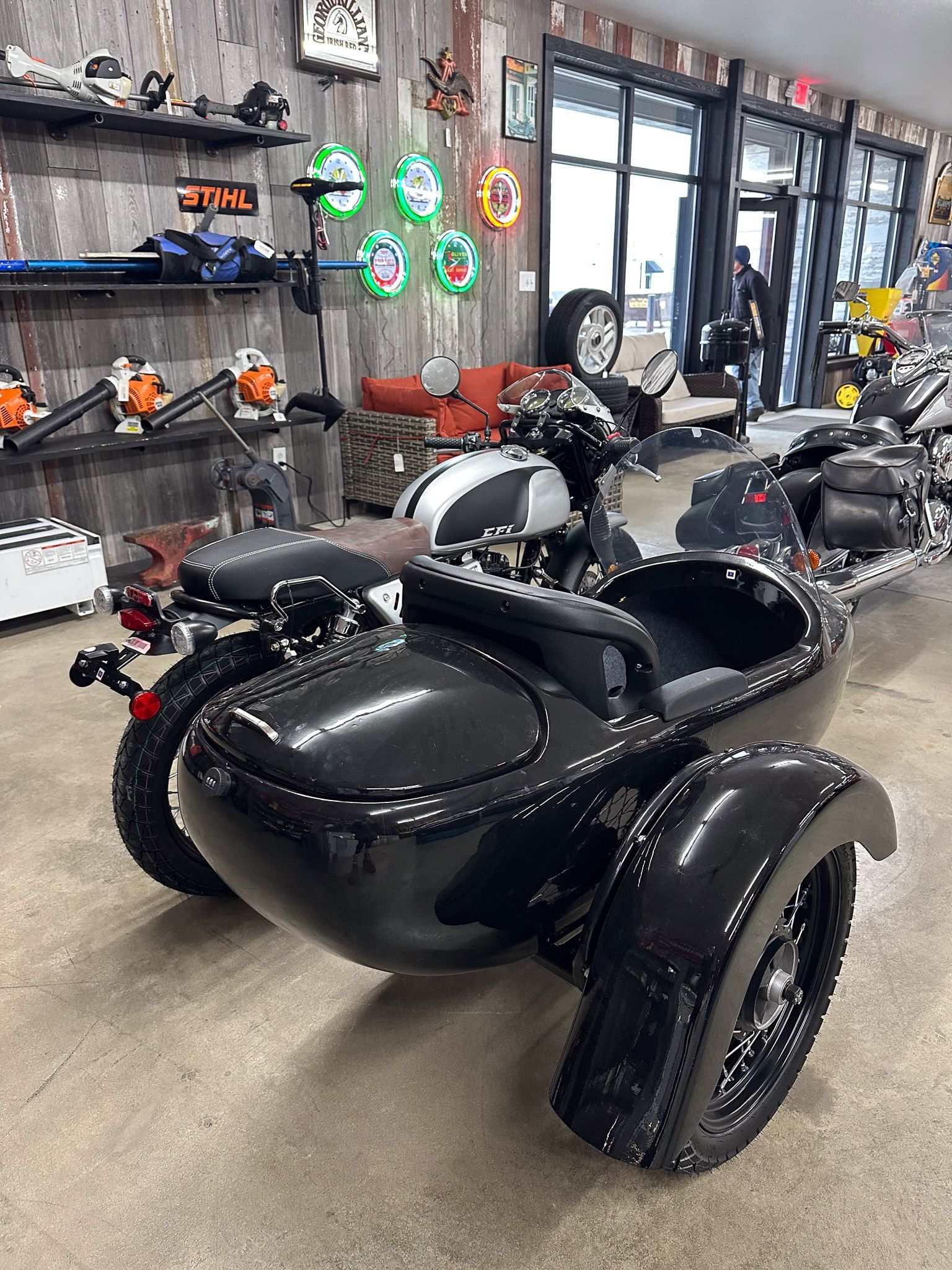 Black motorcycle with sidecar in a showroom.