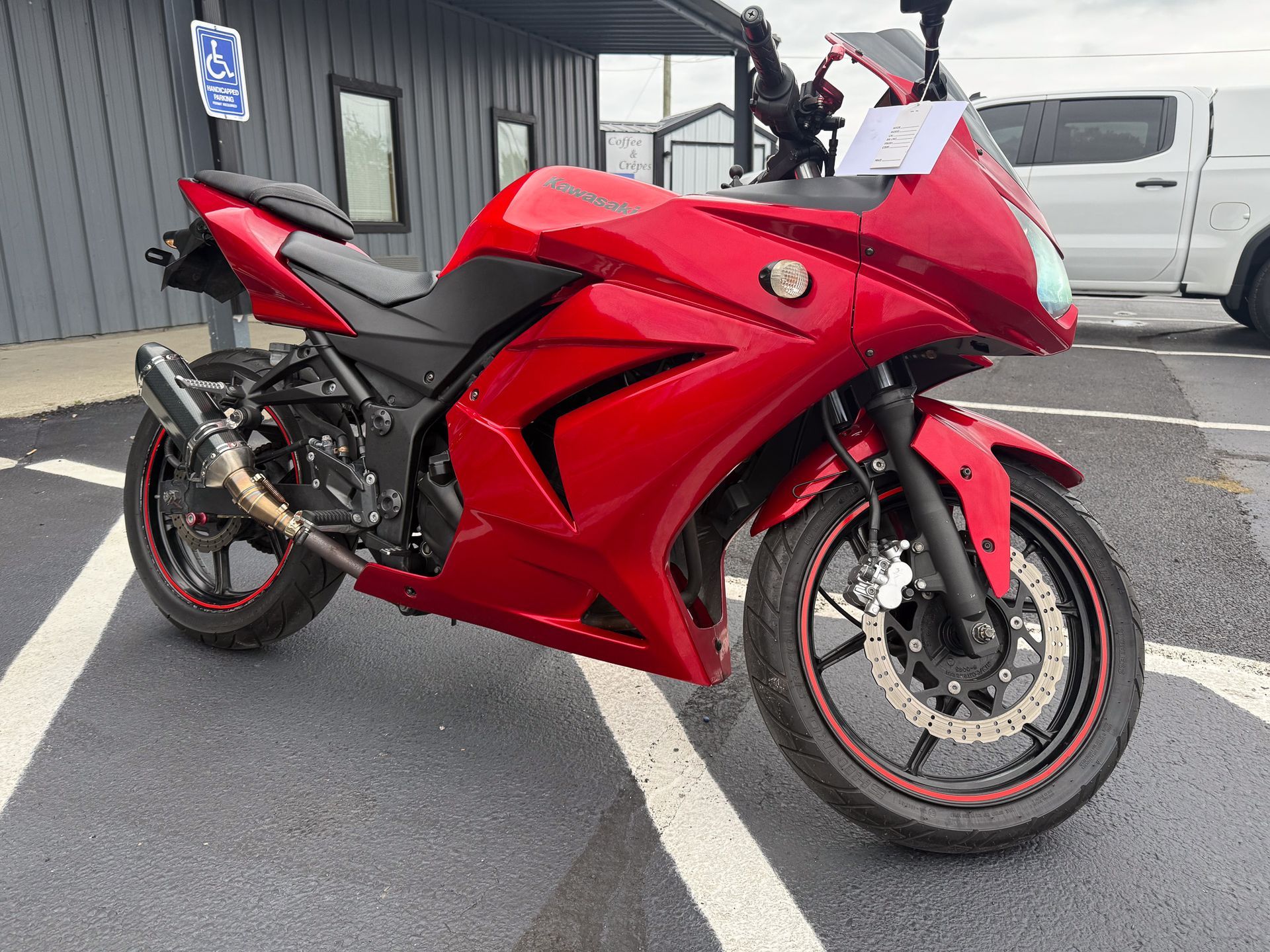 Red Kawasaki Ninja motorcycle parked on asphalt.
