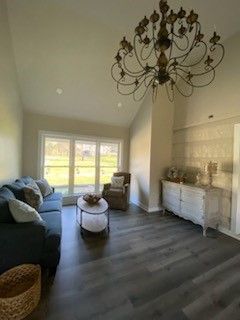 A living room with a couch, chair, table, and chandelier