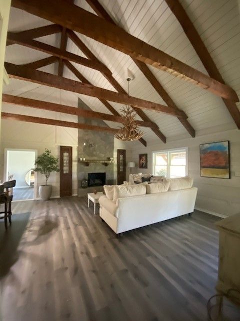 A living room with a white couch and wooden beams