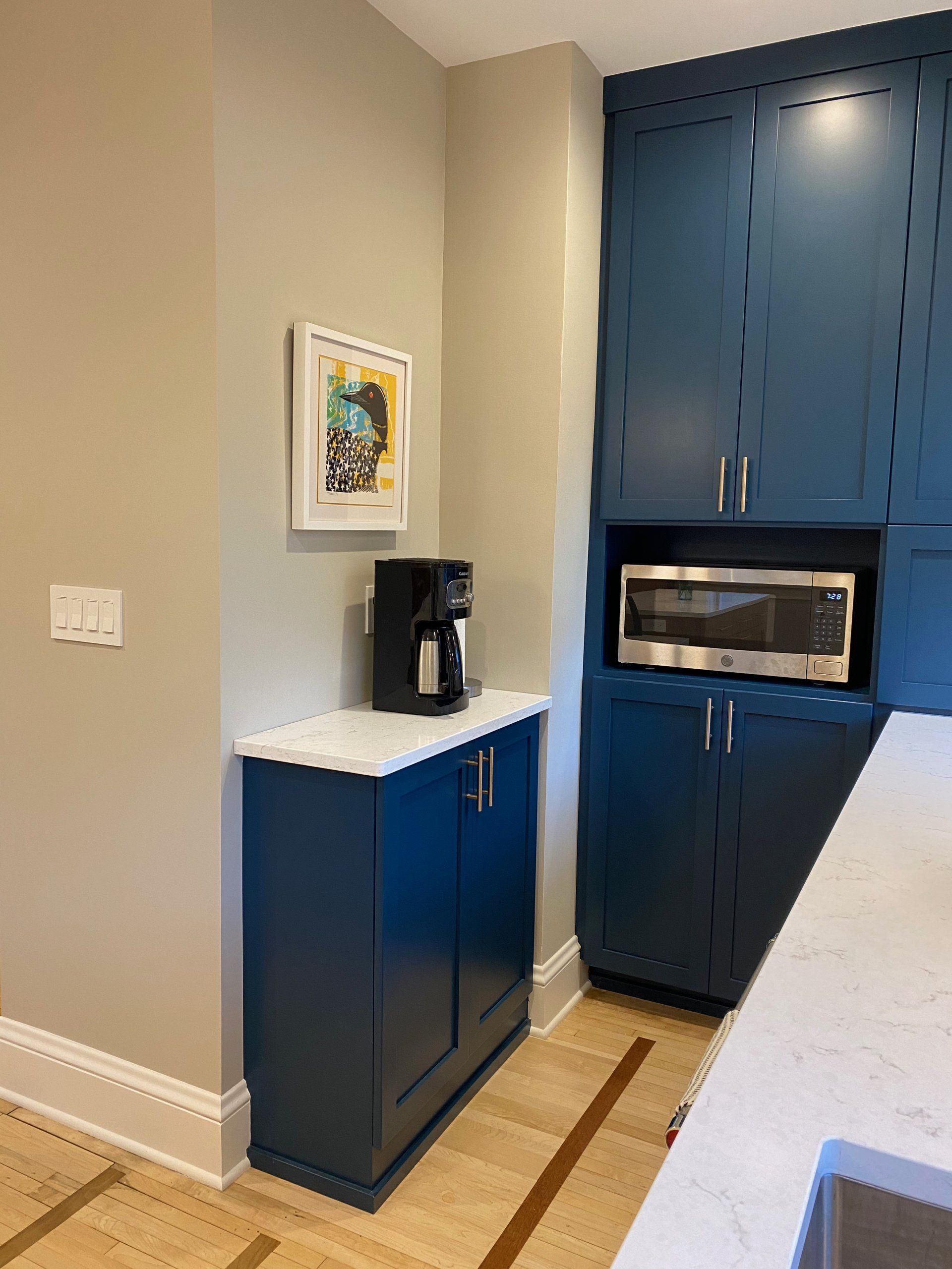 coffee maker on top of a blue kitchen cabinet