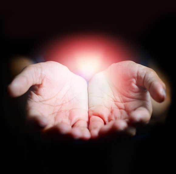 A person is holding a light in their hands.
