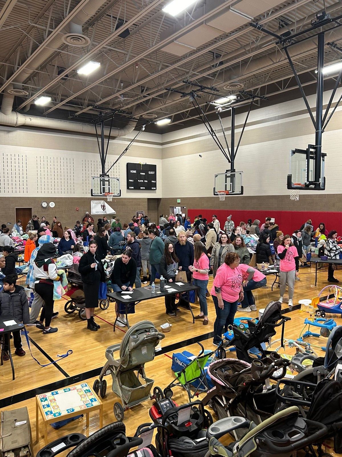 A large group of people are gathered in a gym.