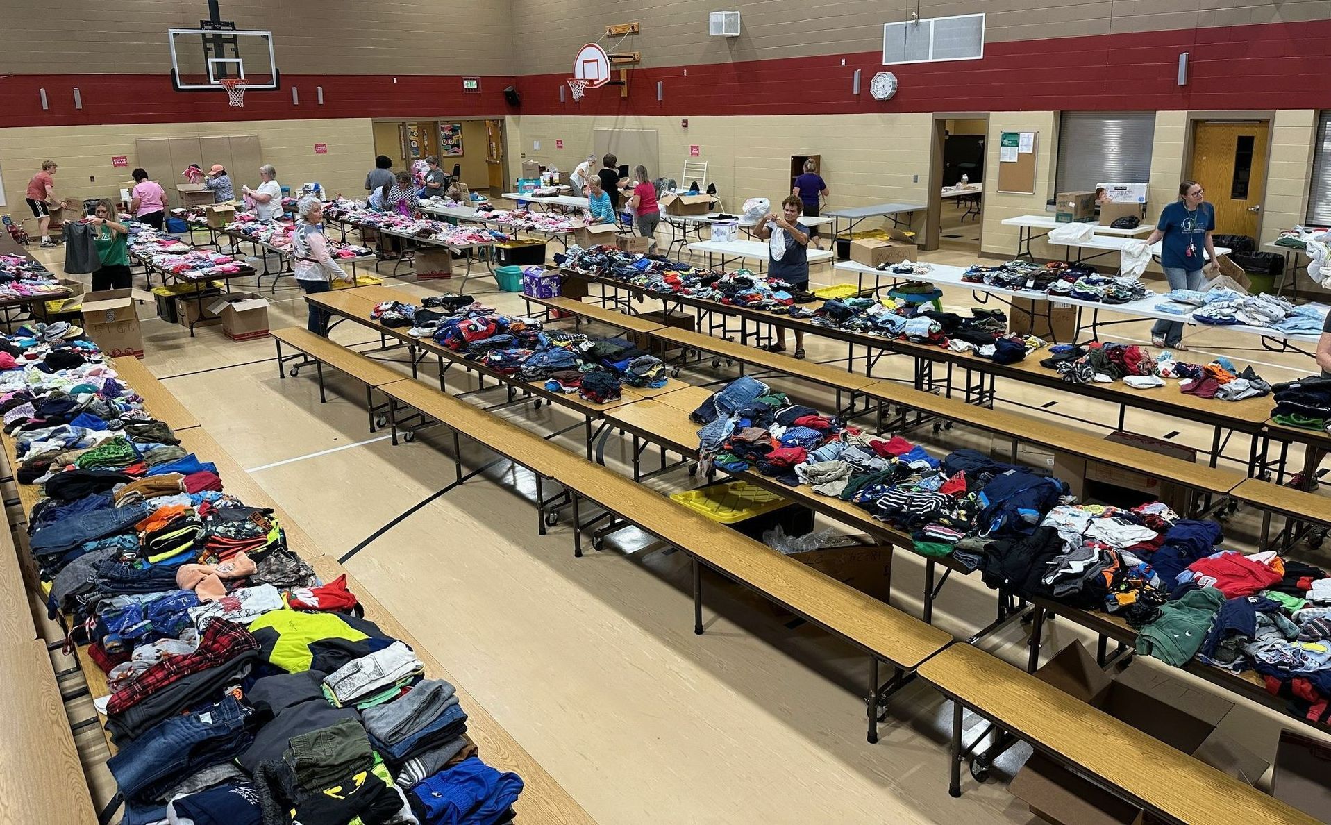 A large room filled with tables and lots of clothes.