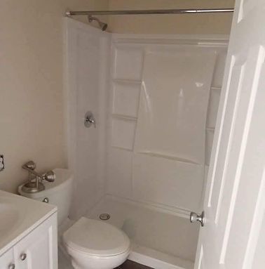 Small bathroom with a white toilet, sink, and bathtub with a shower curtain.