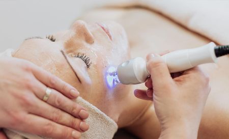 A woman is getting a facial treatment at a spa.