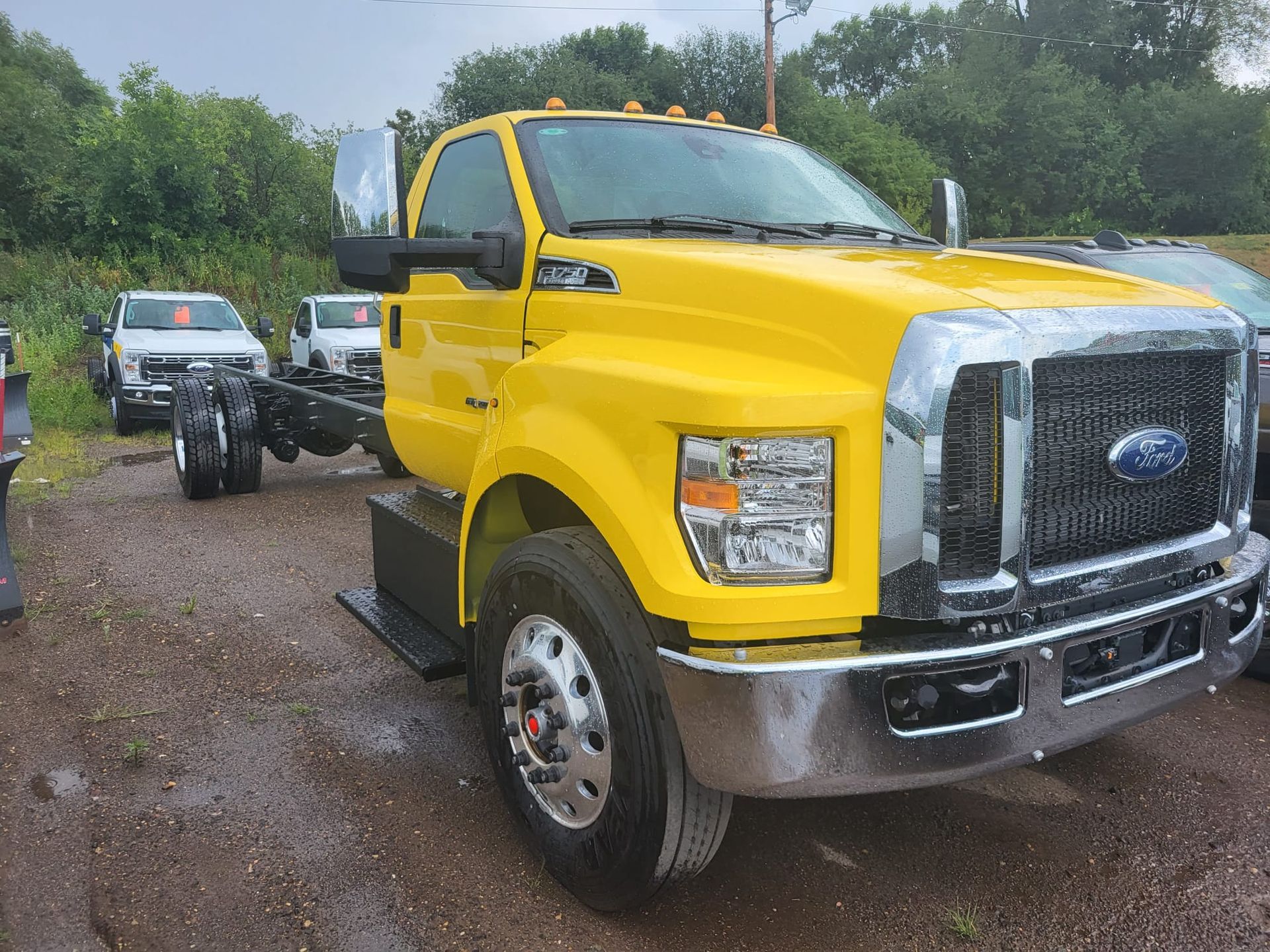 Yellow Ford F-650 truck chassis on display at a dealership.