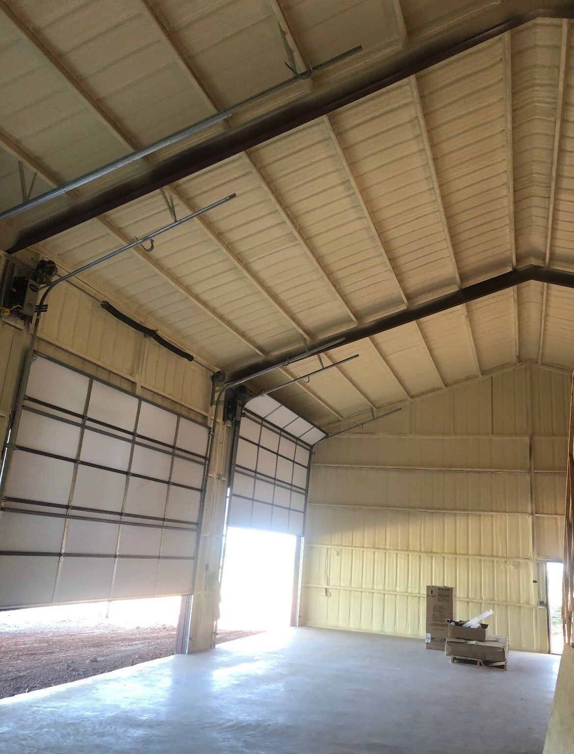 The inside of a large building with a garage door open.