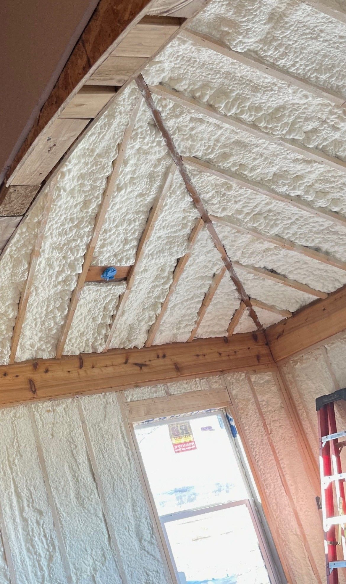A room with a ladder and a ceiling covered in foam.