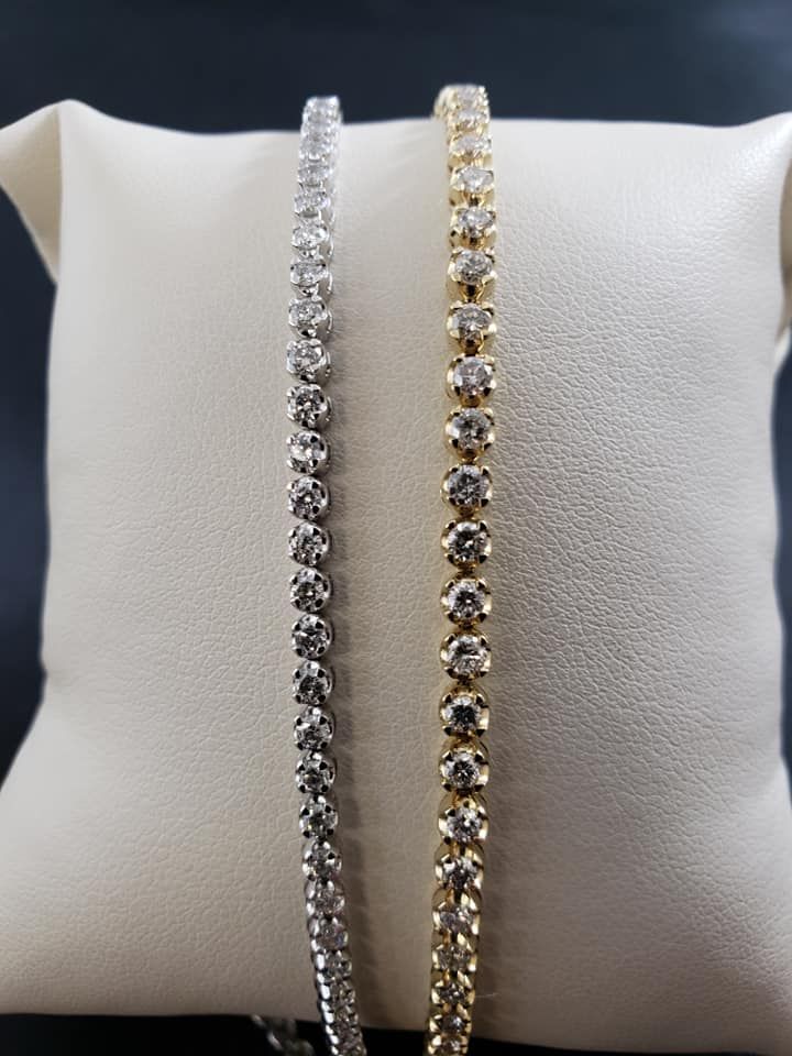 Two bracelets are sitting on a white pillow