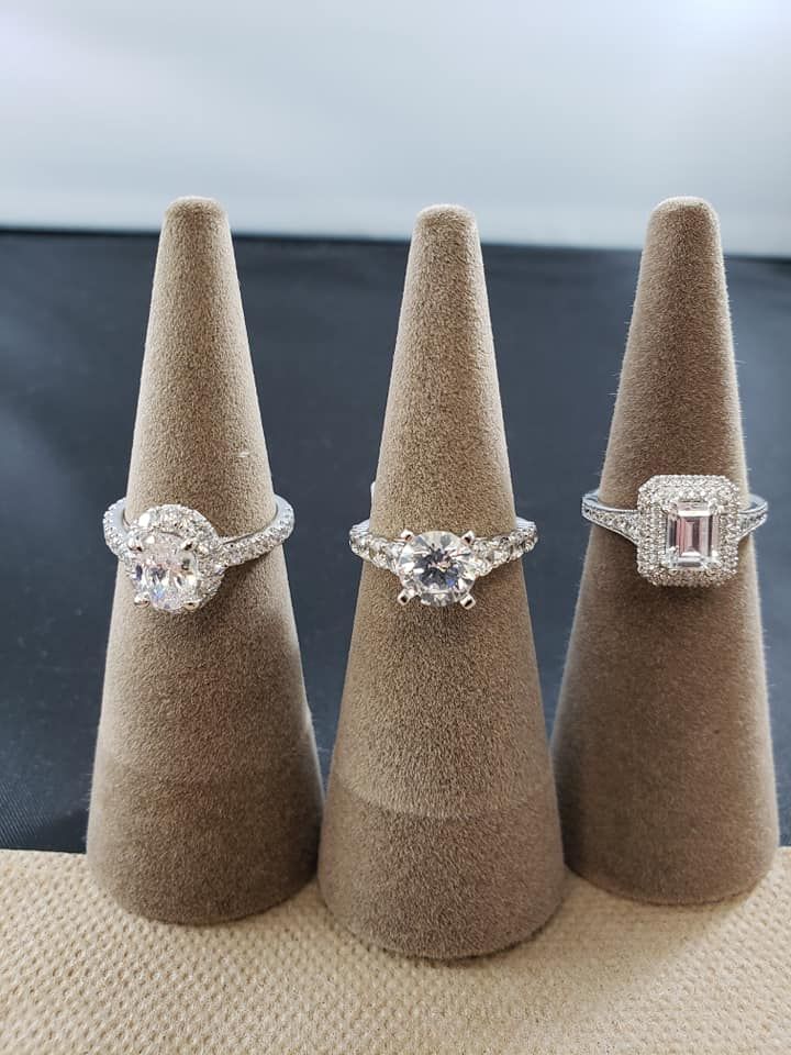 Three rings are sitting on a ring holder on a table.