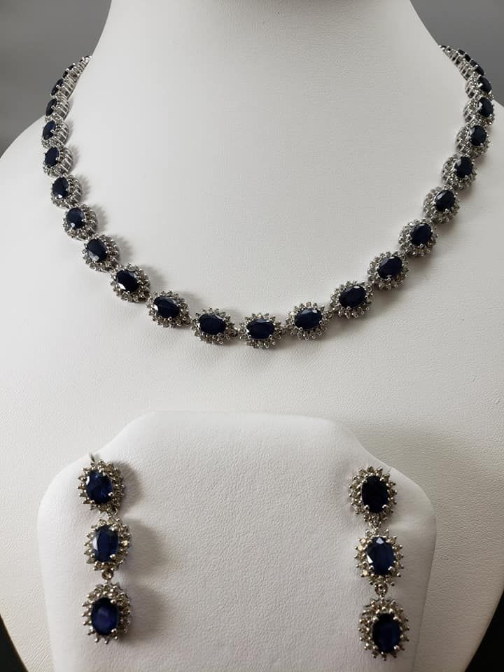 A necklace and earring set with blue stones on a mannequin