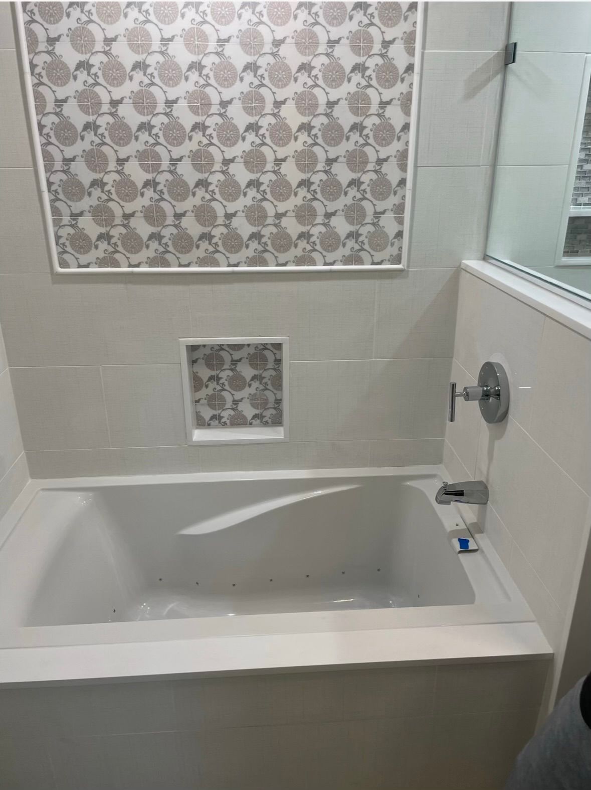 A bathtub in a bathroom with a picture on the wall above it.