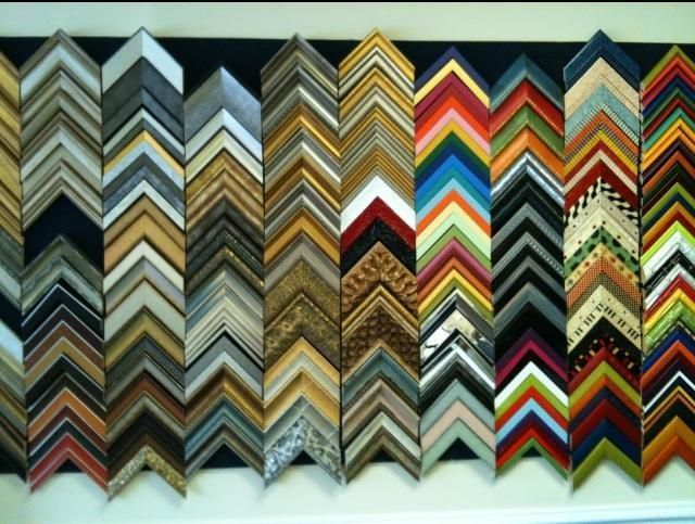 A business card is sitting on top of a pile of frames