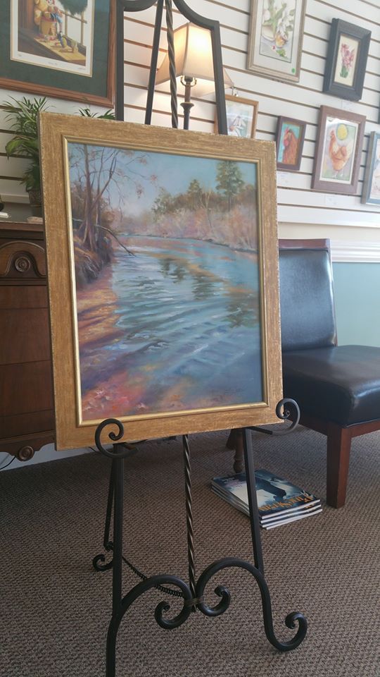 A painting is sitting on an easel in a room.