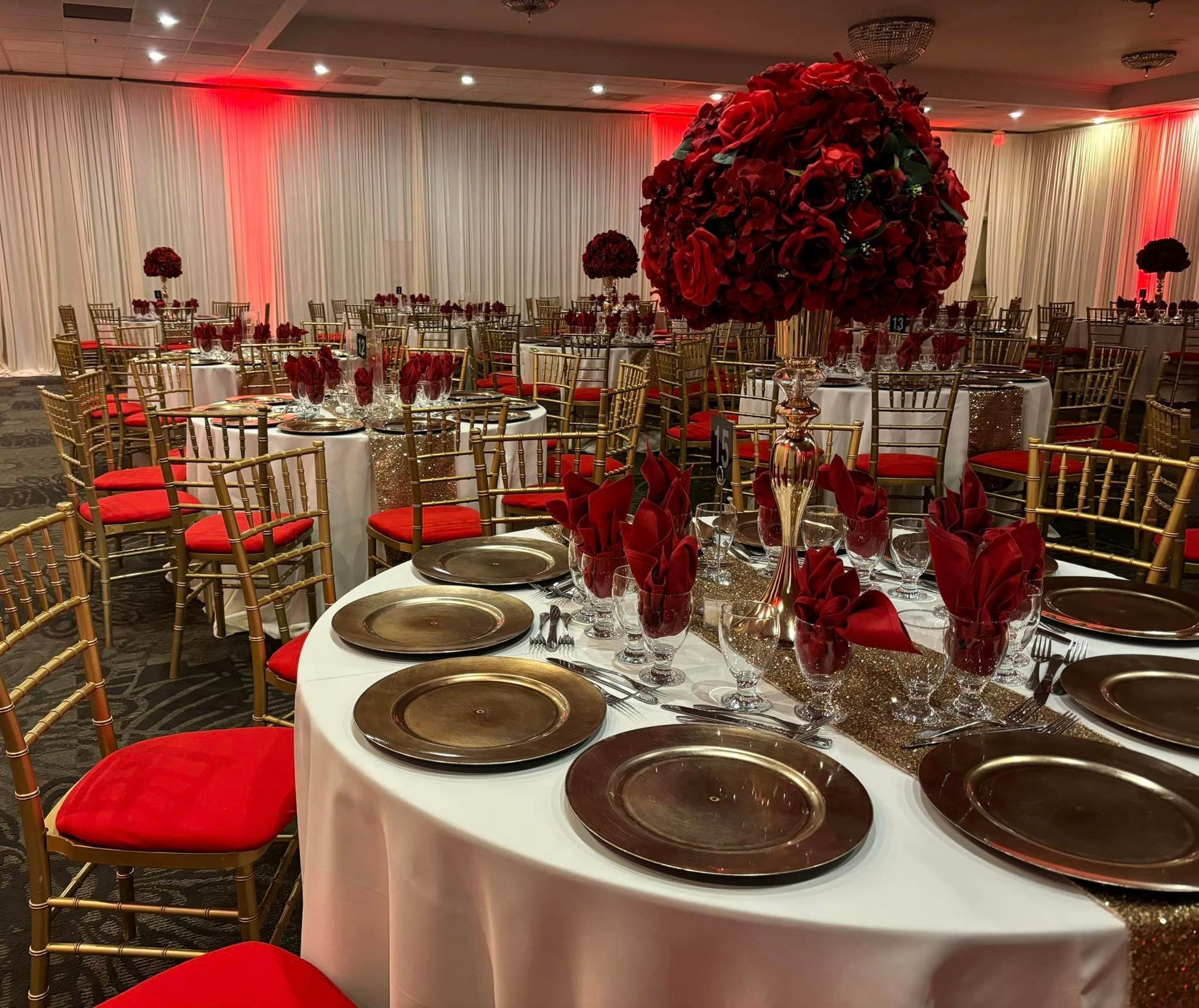 A large room filled with tables and chairs decorated for a wedding reception.