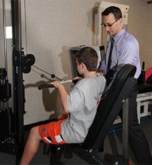 Boy using pulley machine