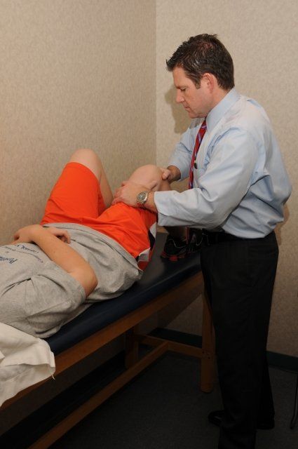 Therapist examining boy's knee