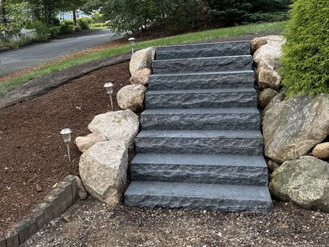 A set of stone stairs surrounded by rocks in a garden.