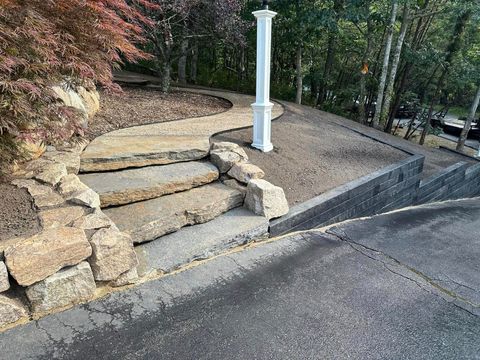 A set of stone stairs leading up to a lush green hillside.